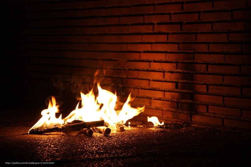 Fire burning against brick wall