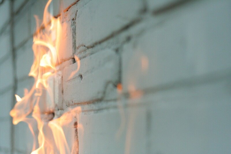 Fire on a white brick wall