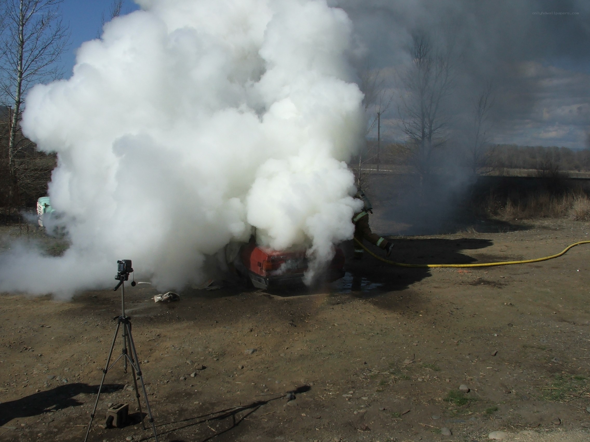 Firefighter extinguishing burning car