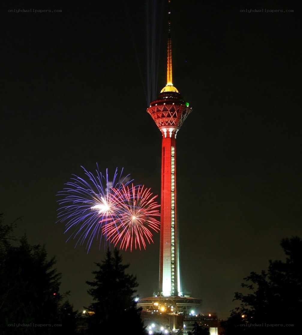 Fireworks at night by a tower