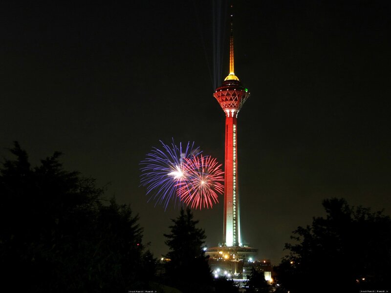 Fireworks at night near a tower
