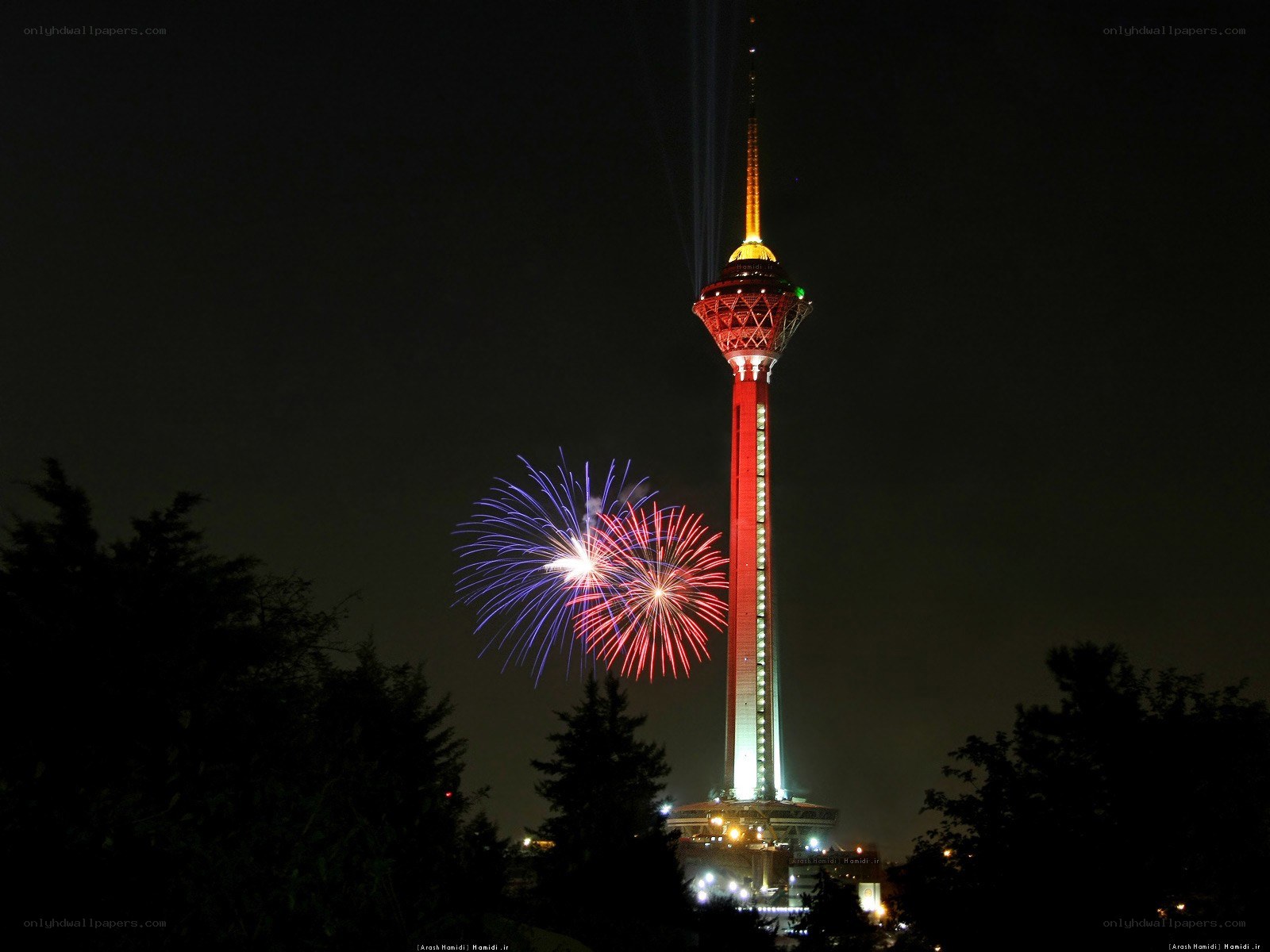 Fireworks at night near a tower