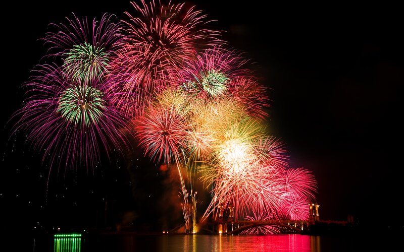 Fireworks Display over Water — Red, Festive, Night, Photograph, Bridge