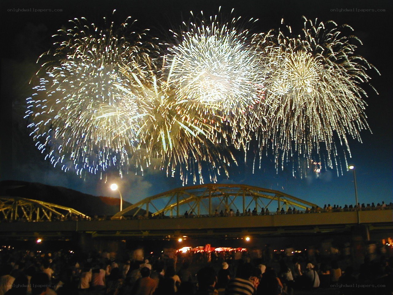 Fireworks over a bridge at night