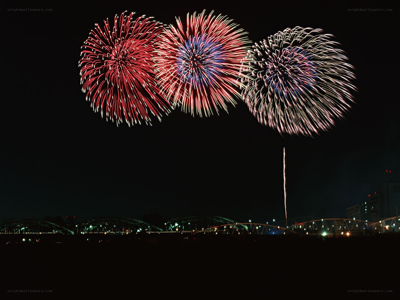 Fireworks over a city bridge