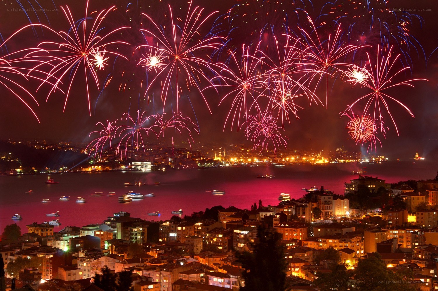 Fireworks over a city harbor