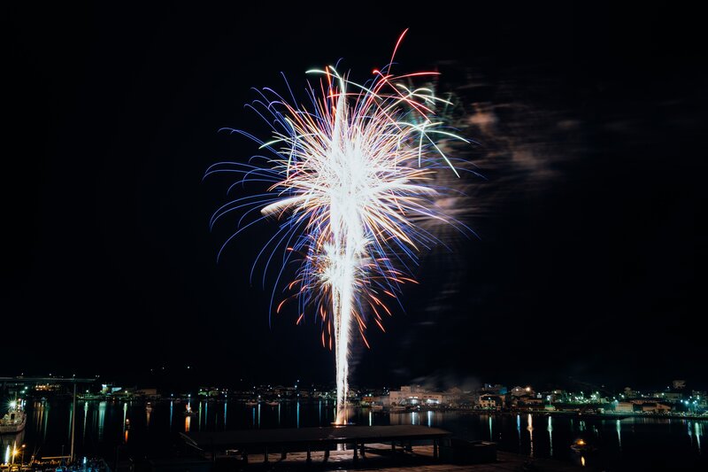 Fireworks over a harbor at night