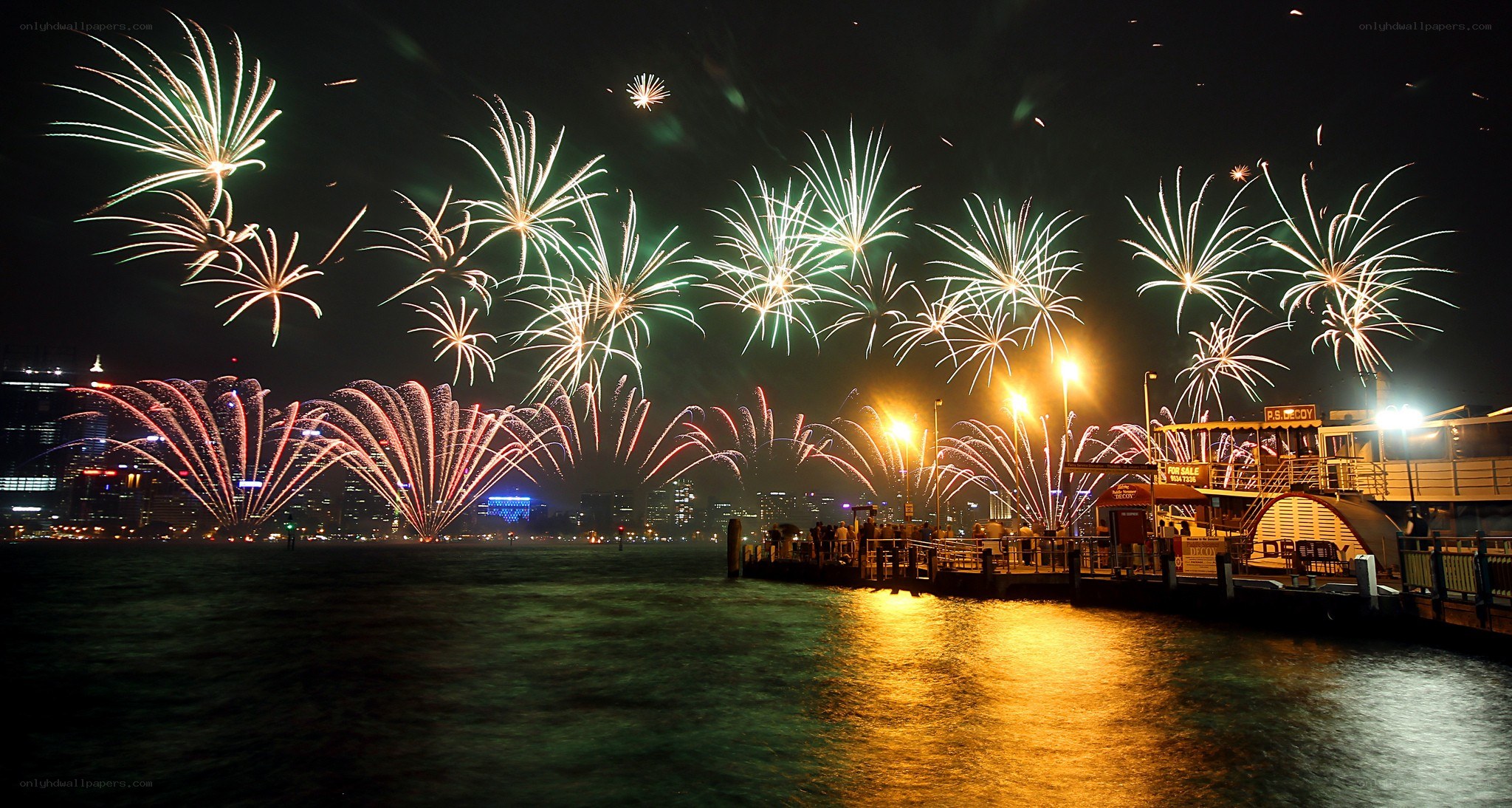 Fireworks over a harbor at night