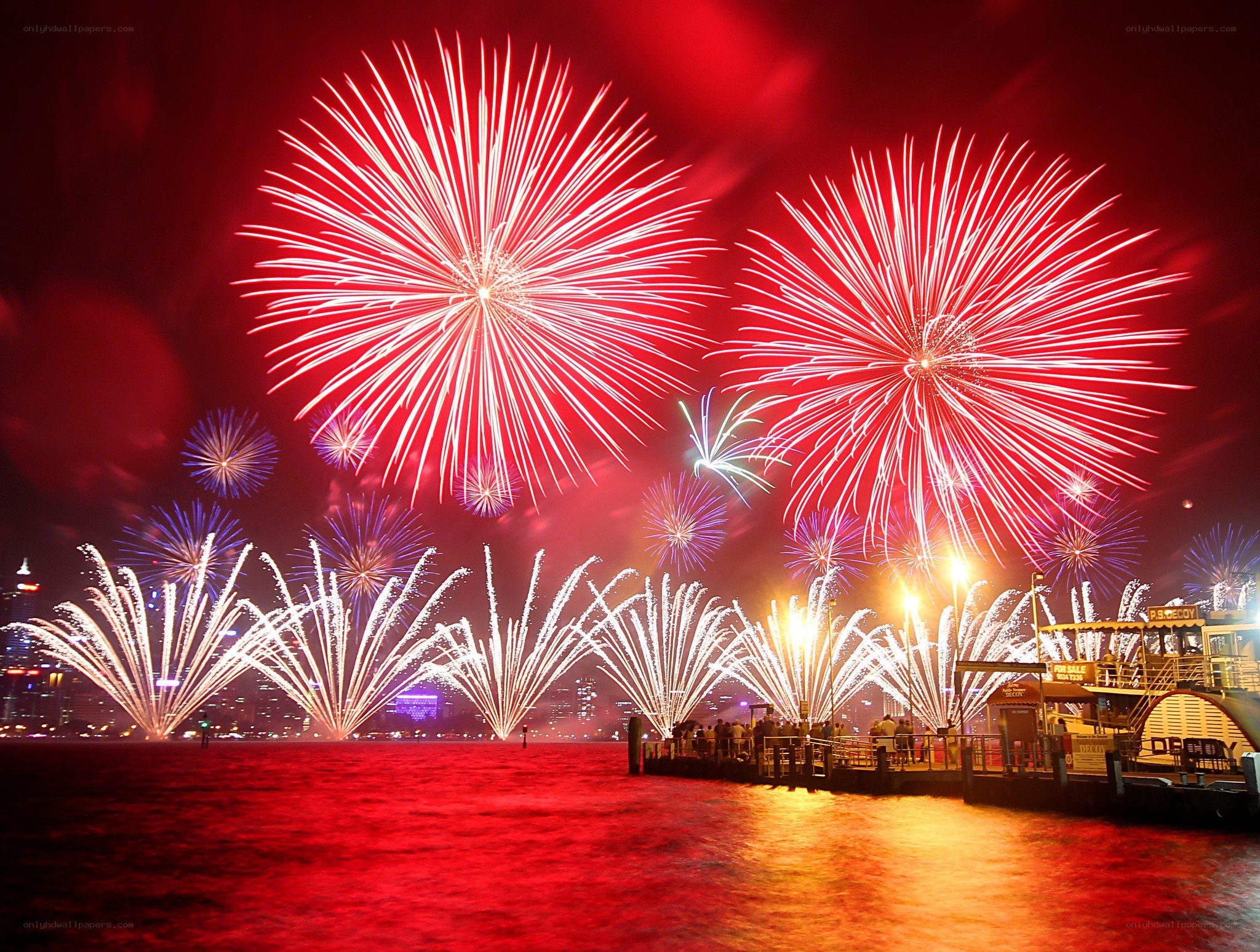 Fireworks over a harbor at night
