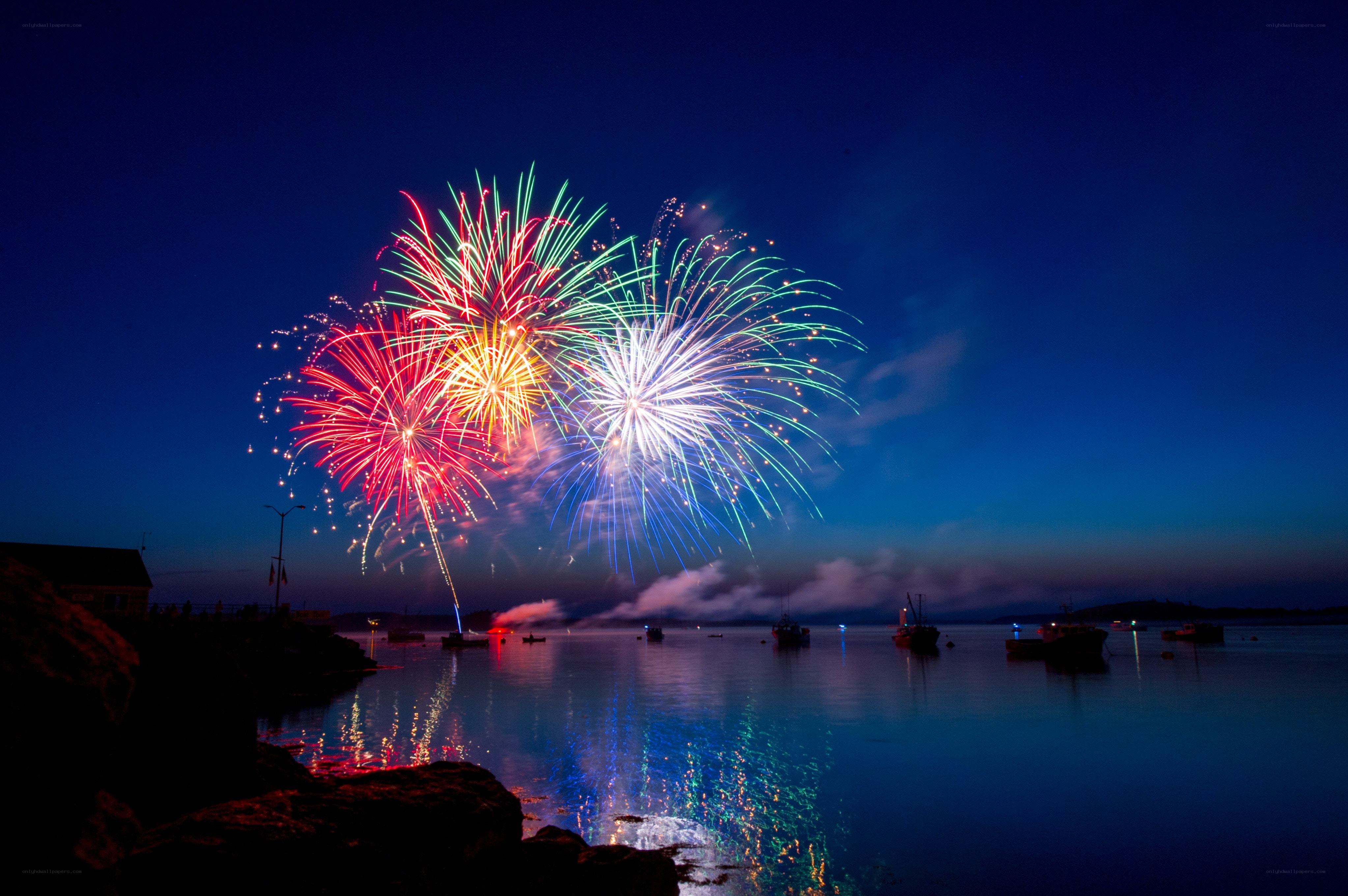 Fireworks over a harbor at night
