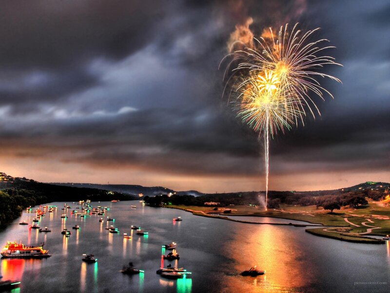 Fireworks over a lake at dusk