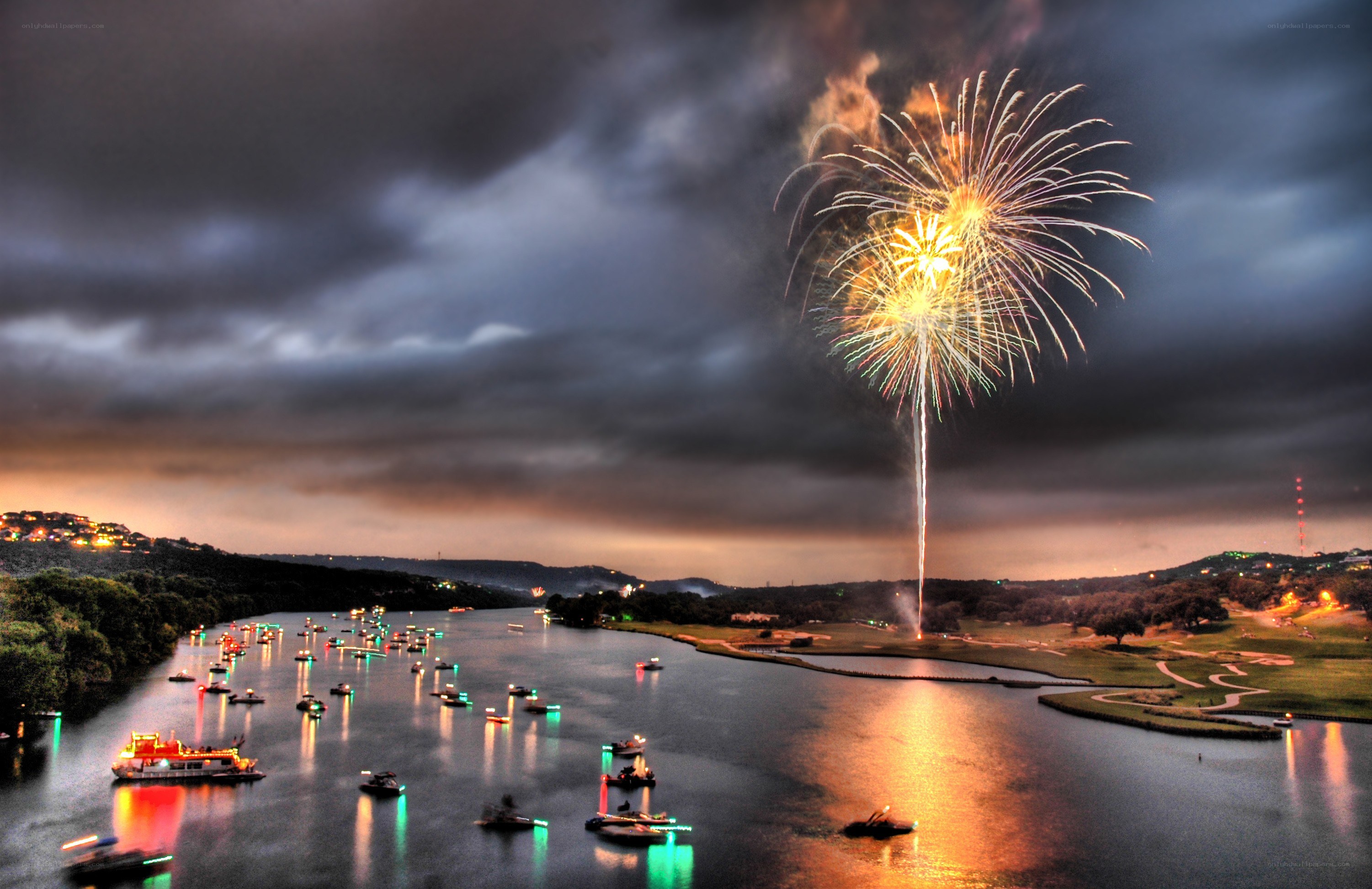Fireworks over a river at dusk