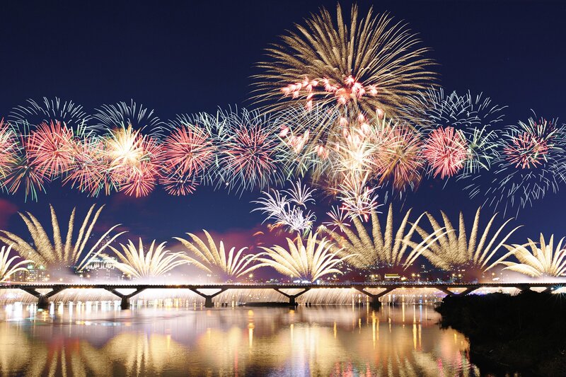Fireworks over a river at night