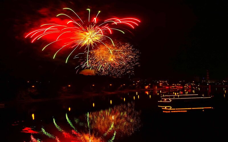 Fireworks over a river at night