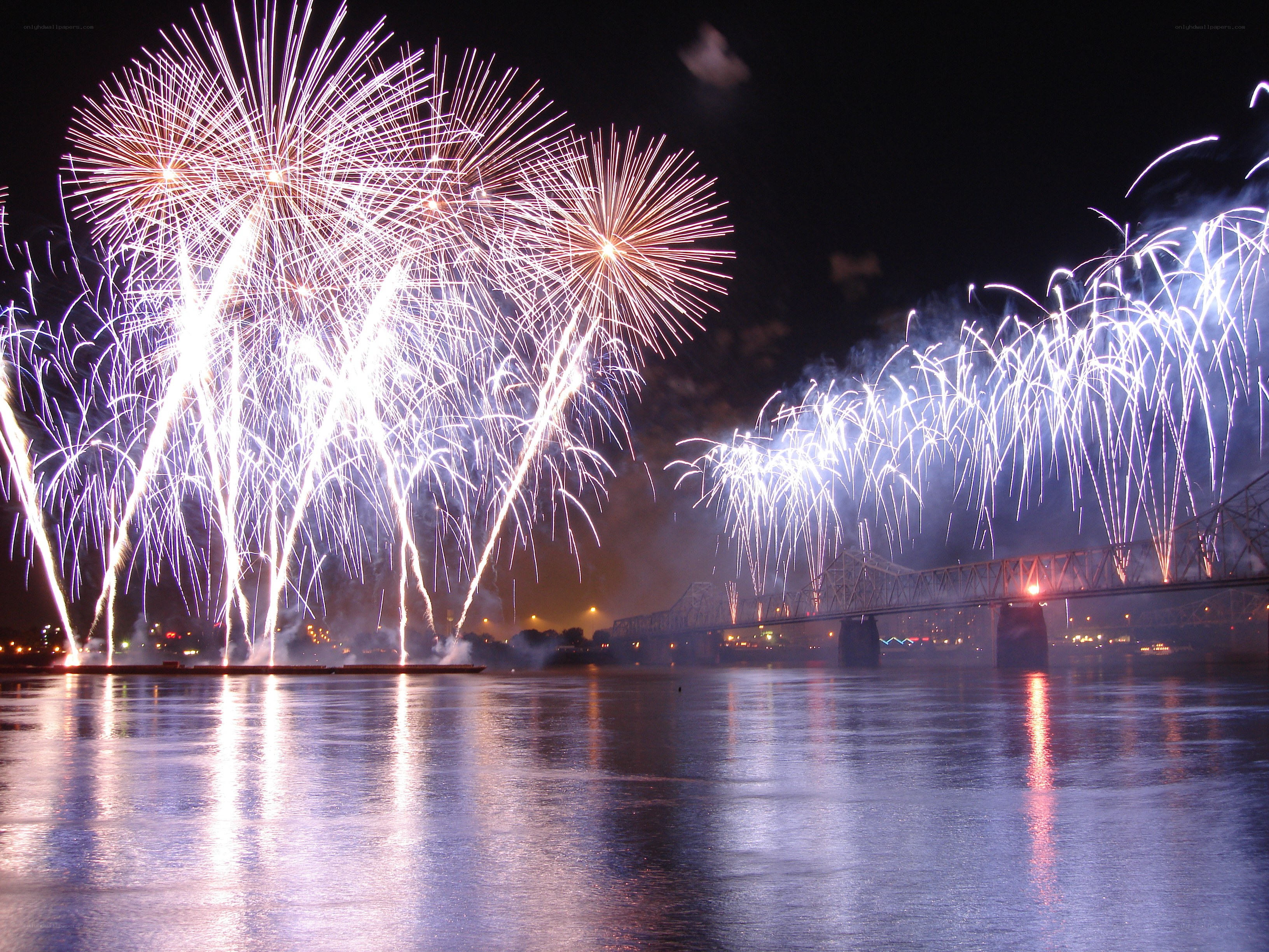 Fireworks over a river bridge
