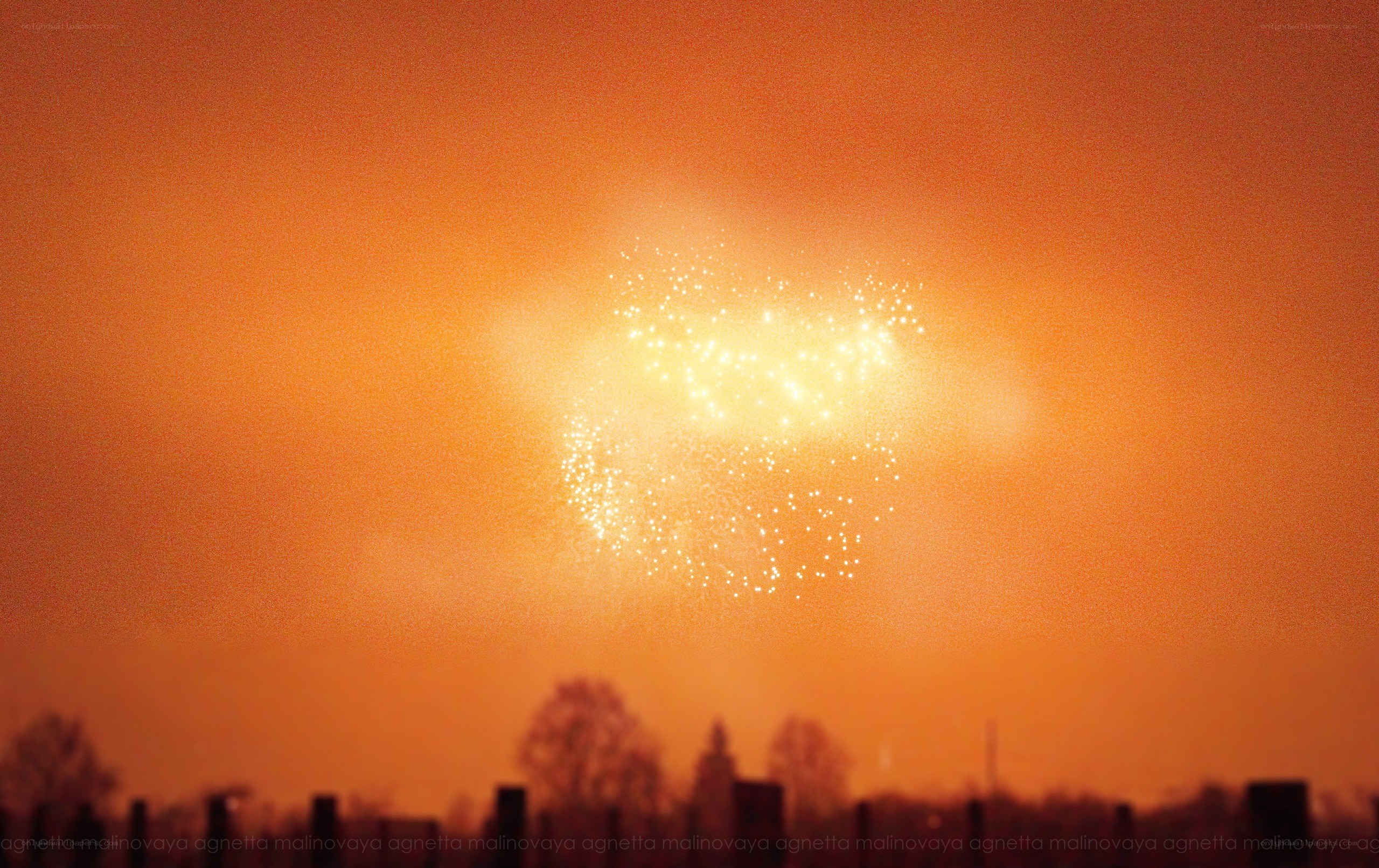 Fireworks over a silhouetted landscape