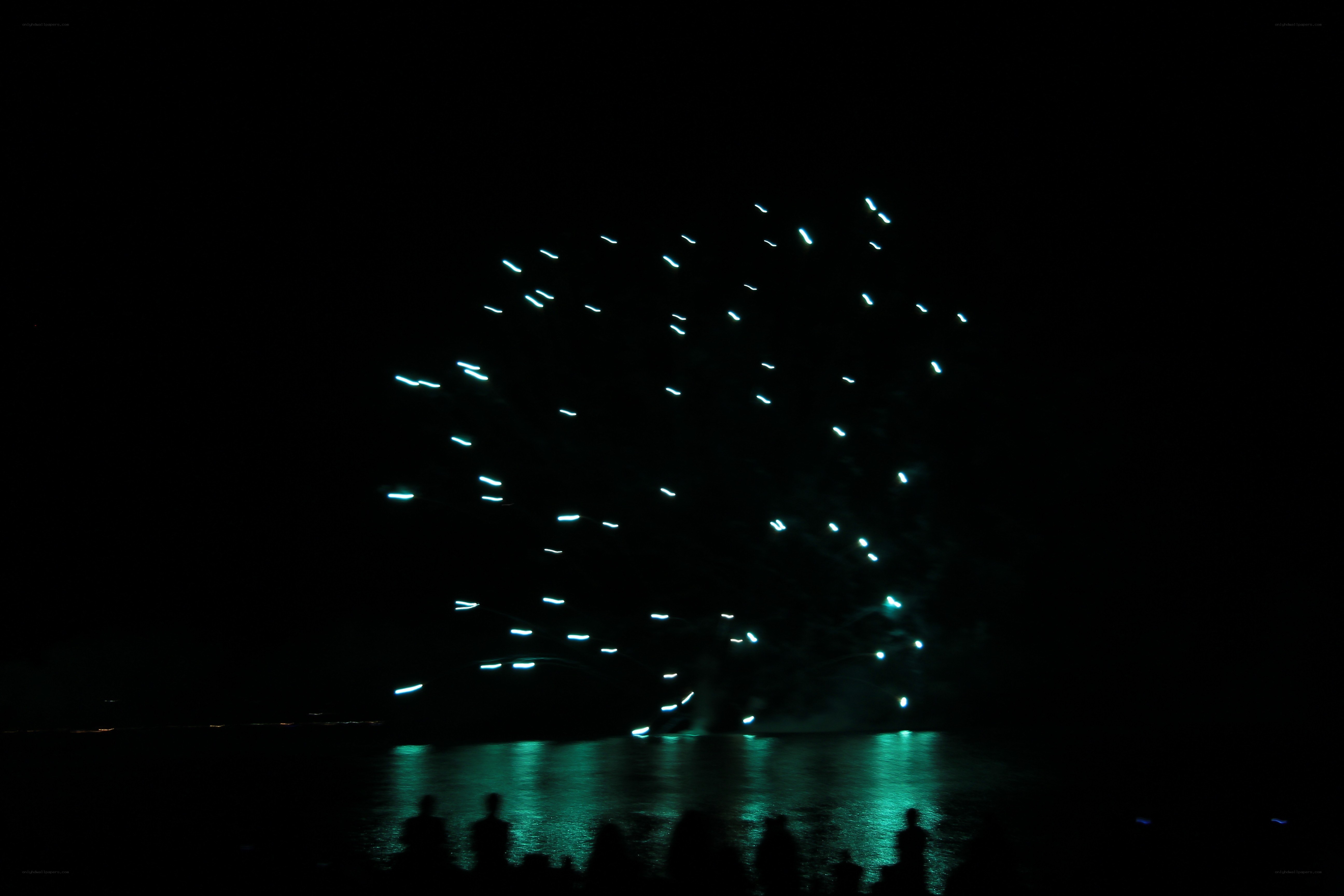 Fireworks over water at night