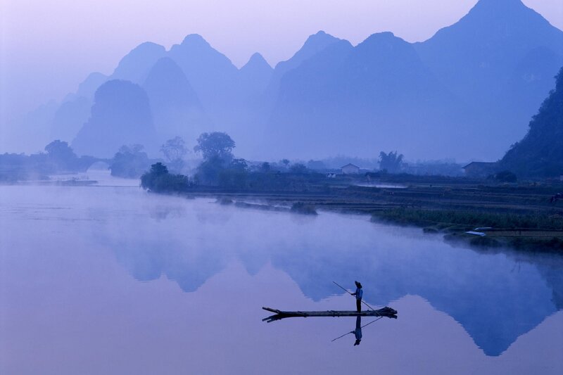 Fisher on a misty river
