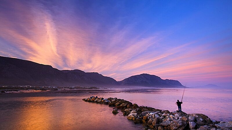 Fisherman at sunset by the sea