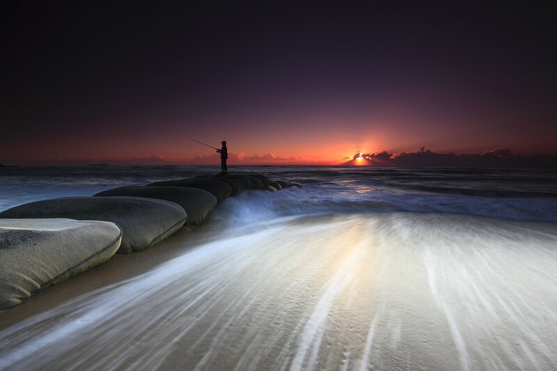Fisherman at sunset on a jetty