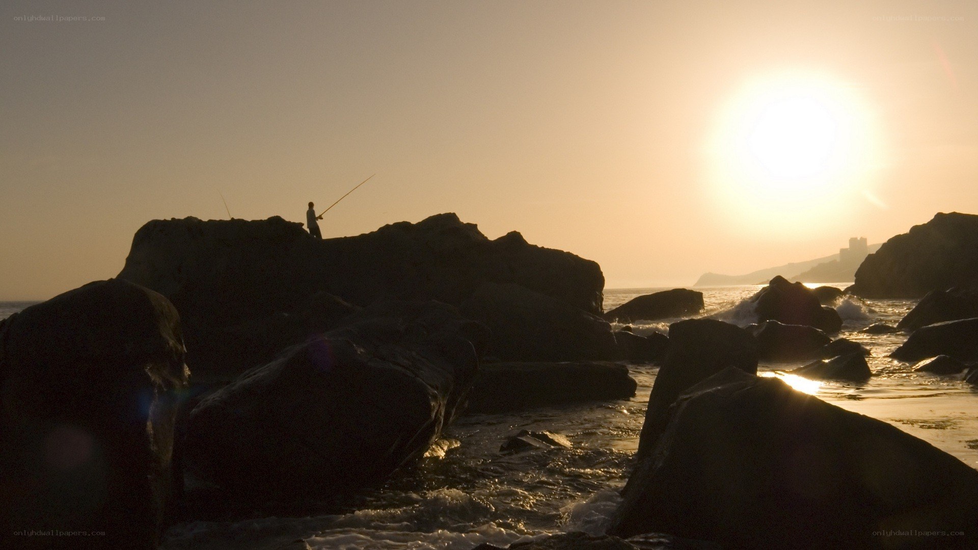 Fisherman at sunset on rocks