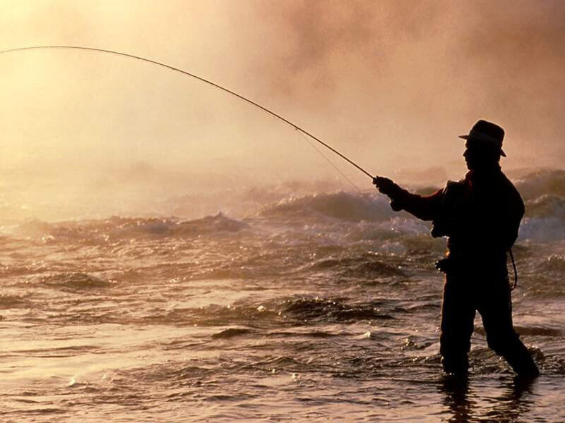 Fisherman casting in ocean