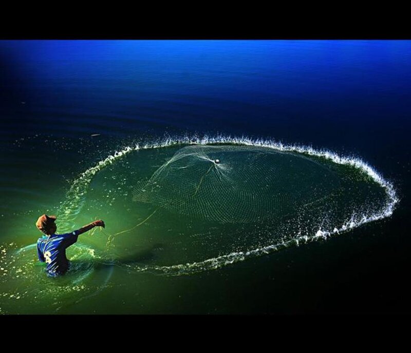 Fisherman casting net in ocean