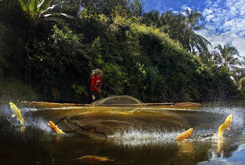 Fisherman casting net in river