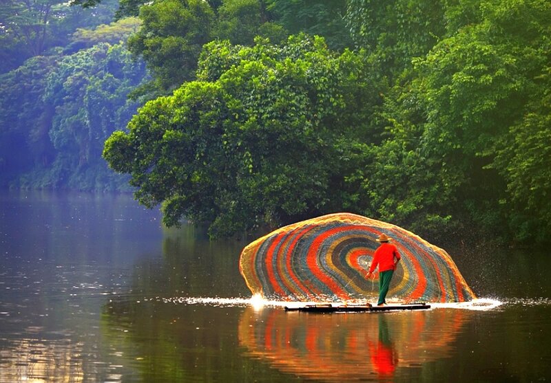 Fisherman casting net on river