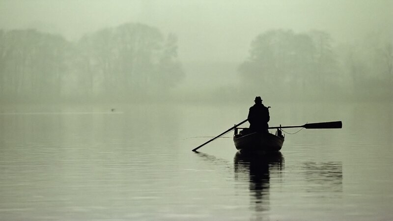 Fisherman in a foggy boat