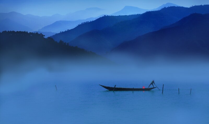 Fisherman on a misty lake