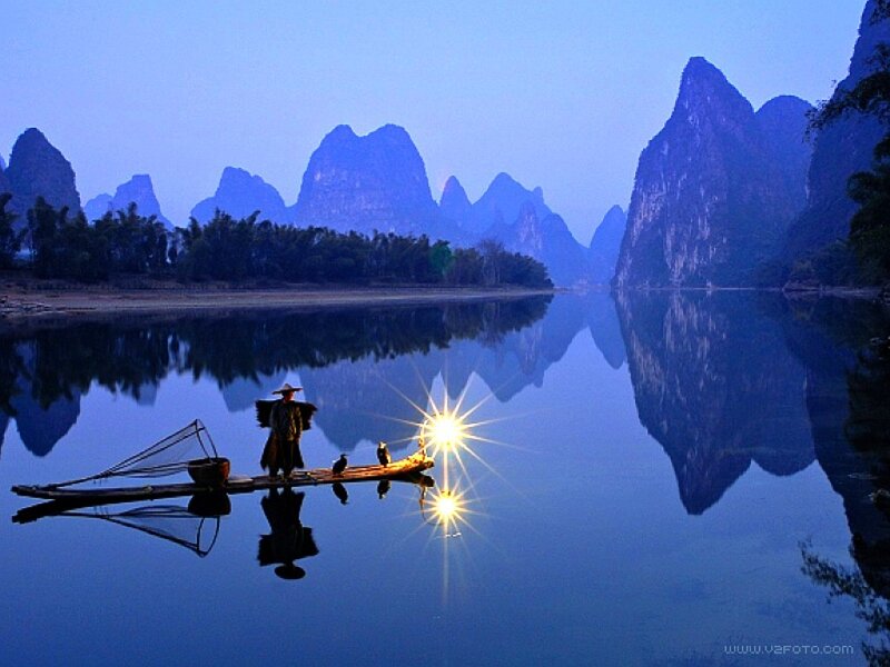 Fisherman on a river at dusk