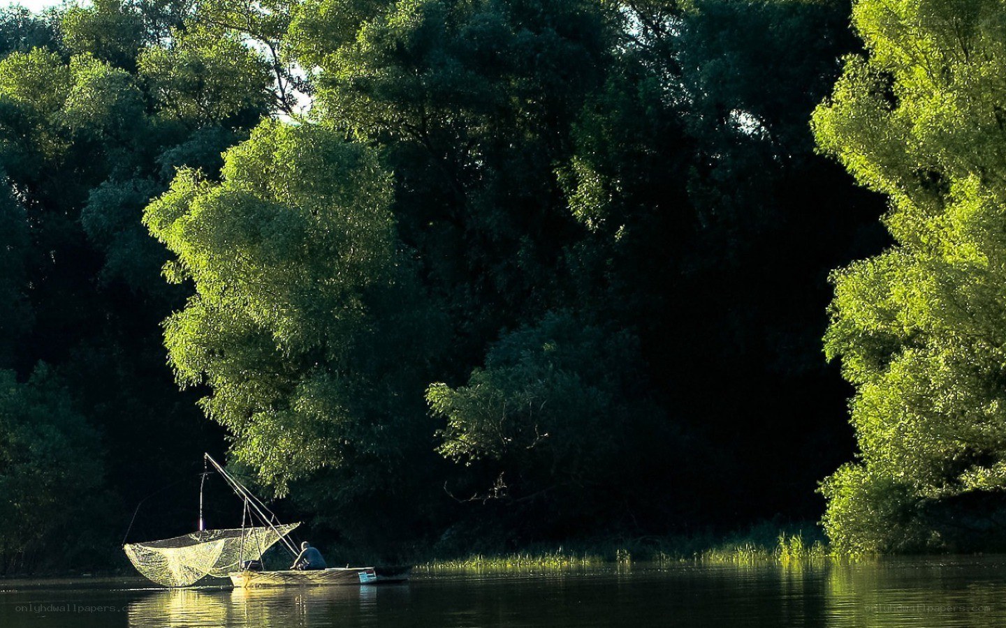 Fisherman on a river at sunset
