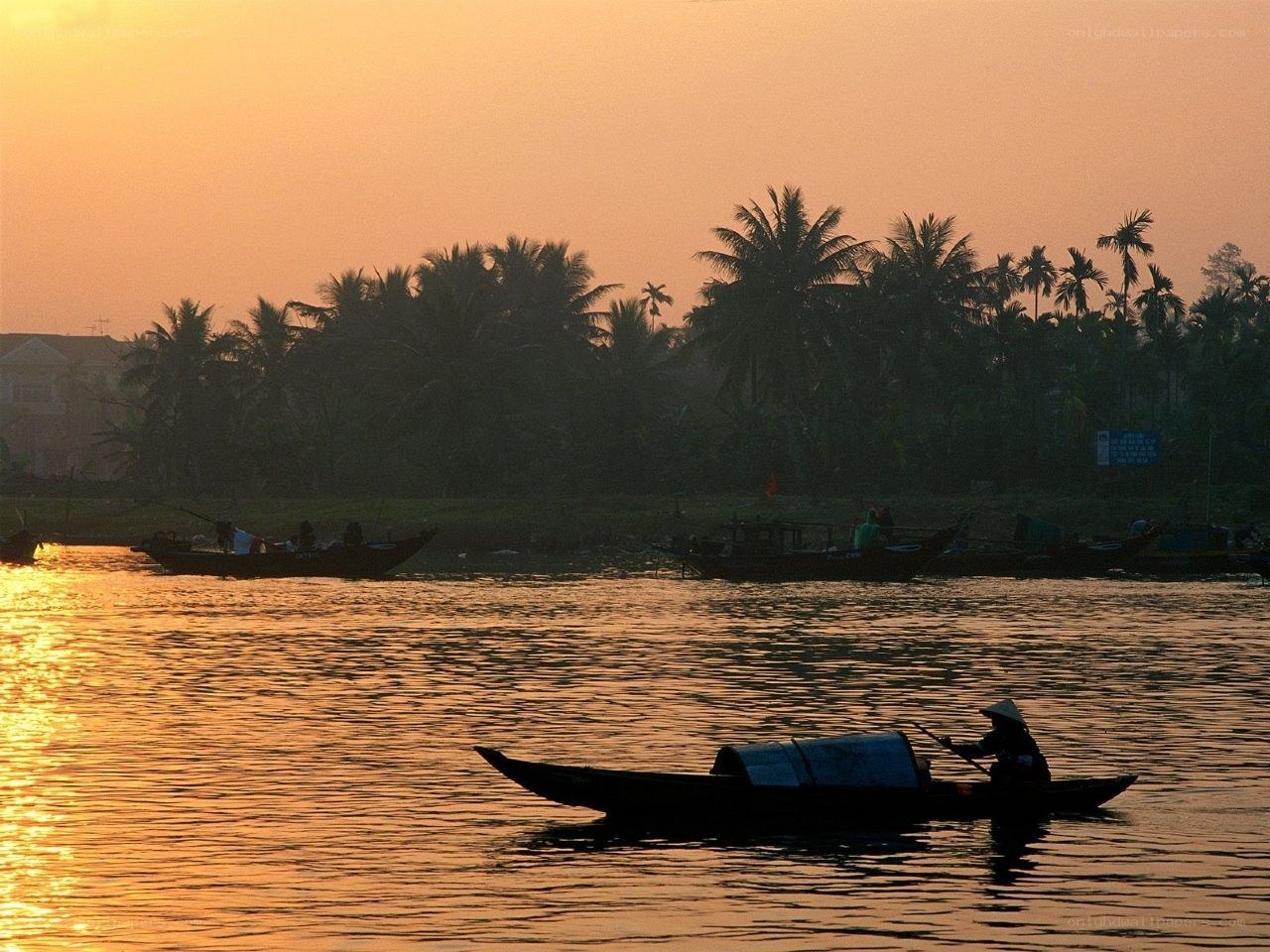 Fisherman on a river at sunset