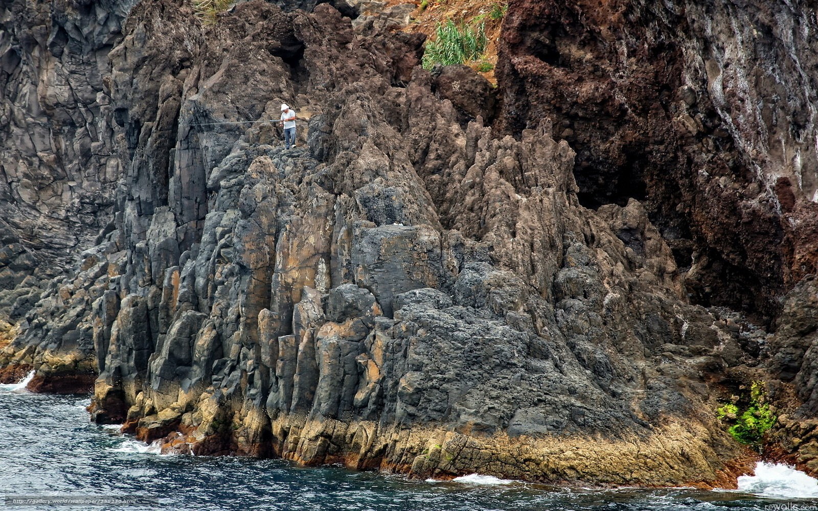Fisherman on rocky cliff