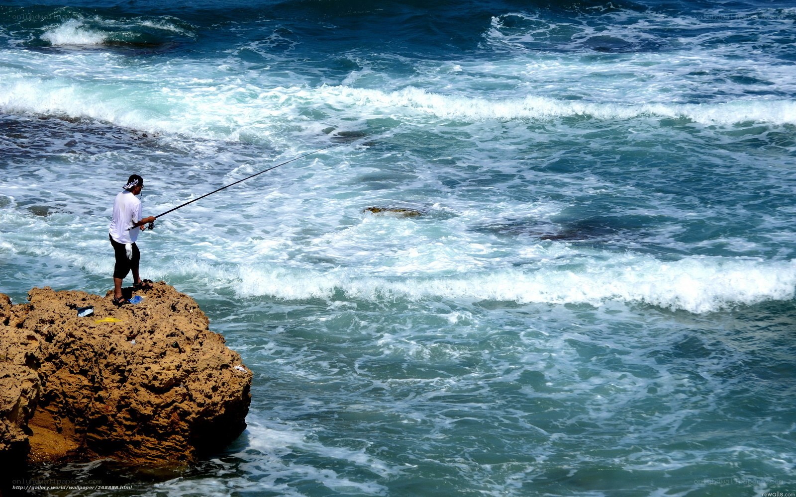 Fisherman on rocky shore