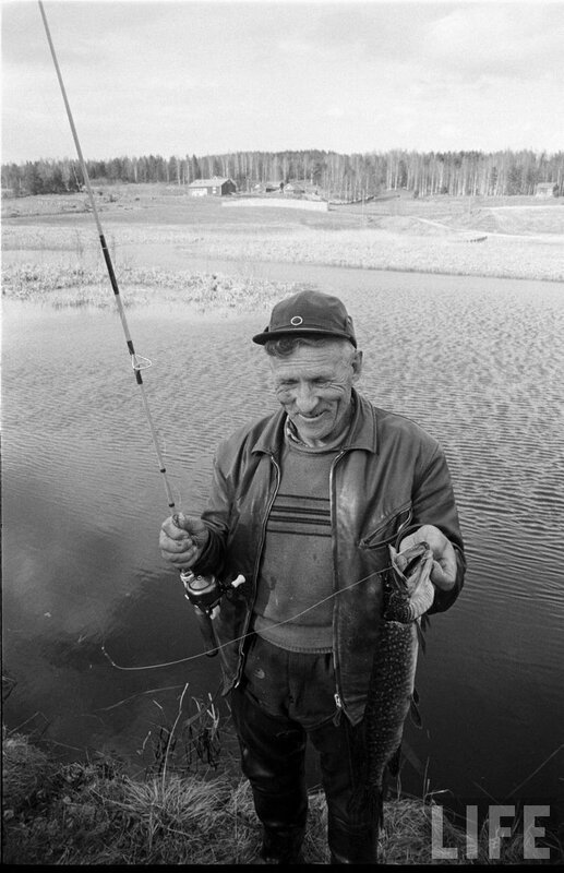 Fisherman with catch by lake