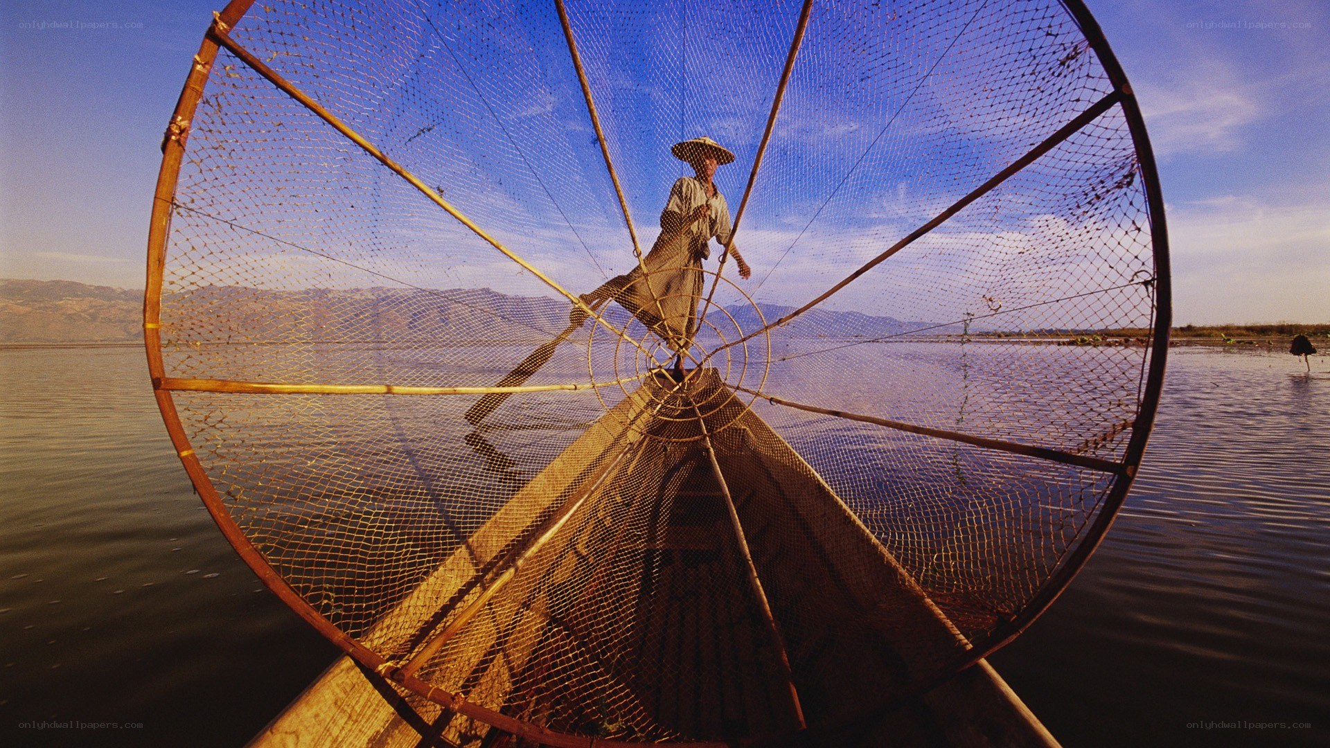 Fisherman with large net on lake