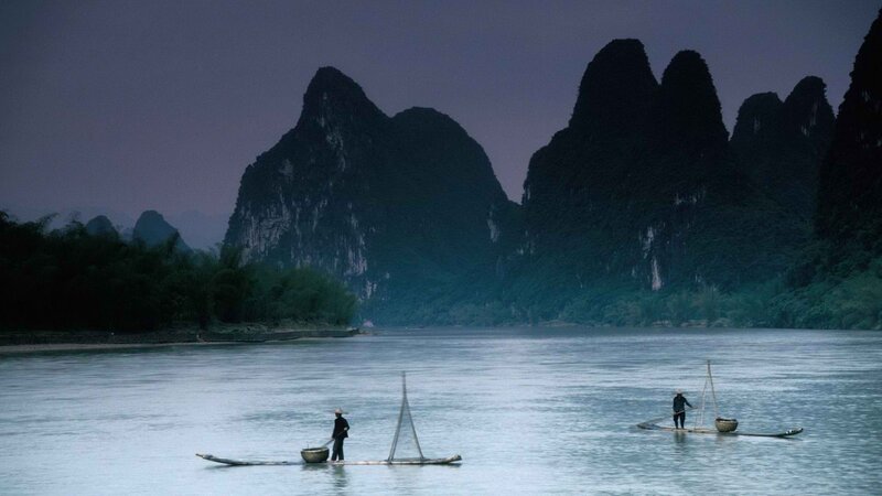 Fishermen on a river at dusk