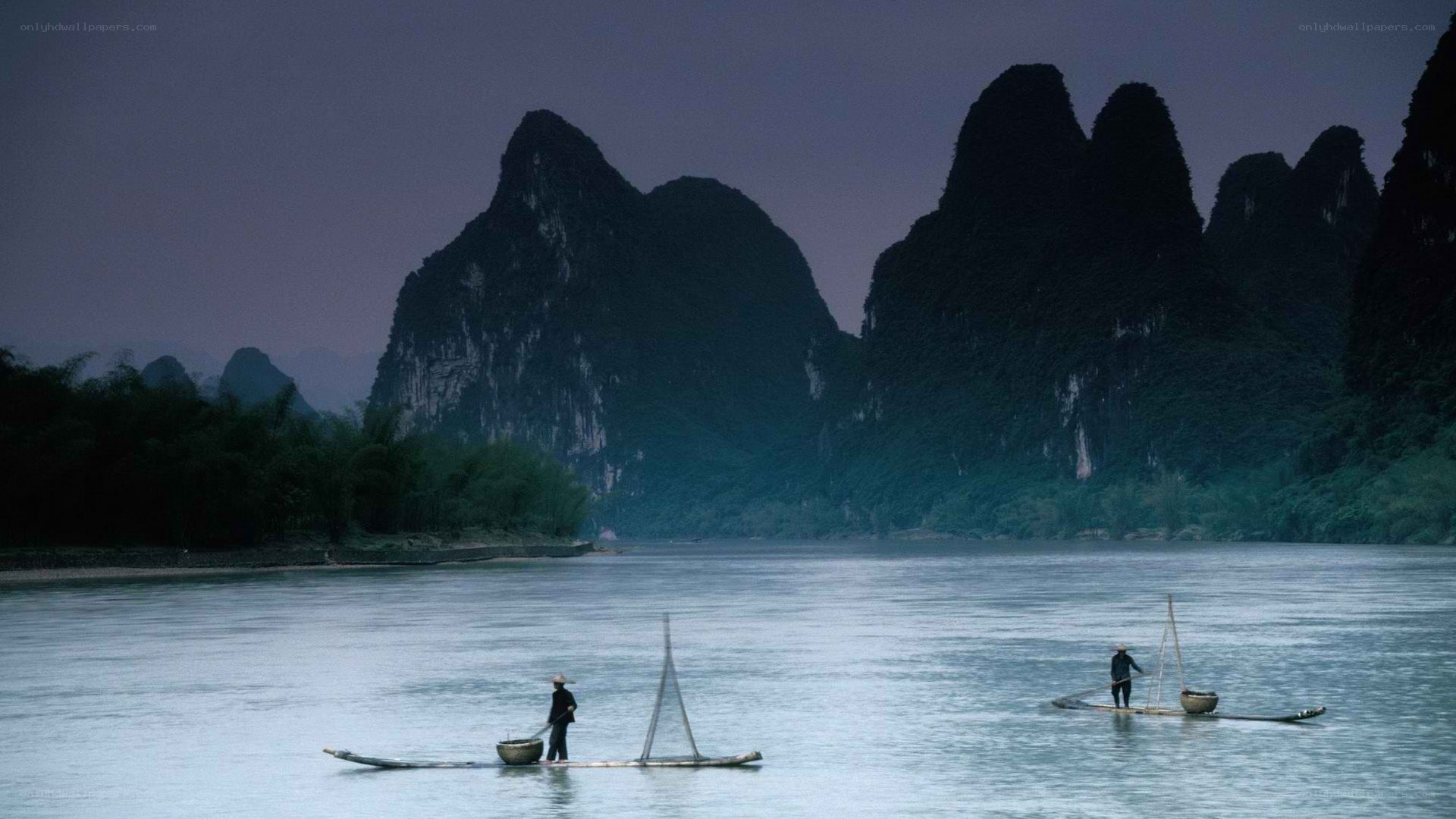 Fishermen on a river at dusk