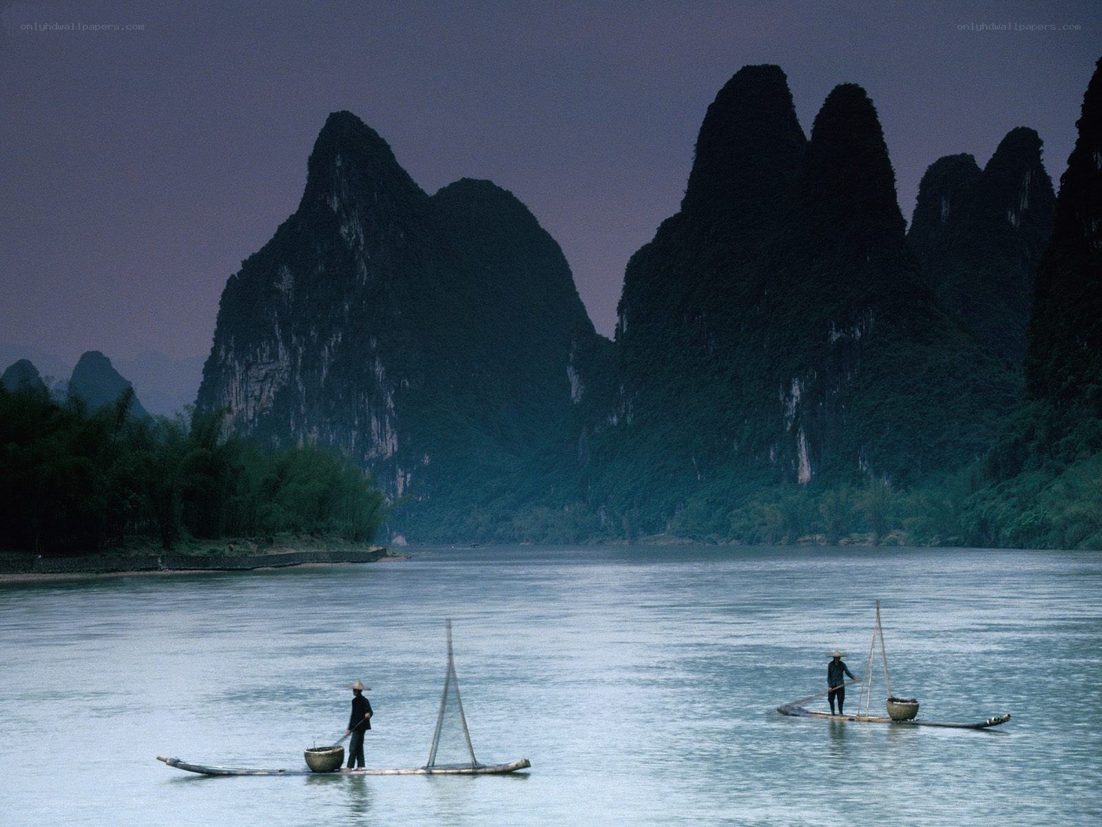 Fishermen on a river at dusk