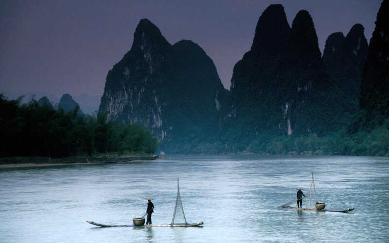Fishermen on a river at dusk