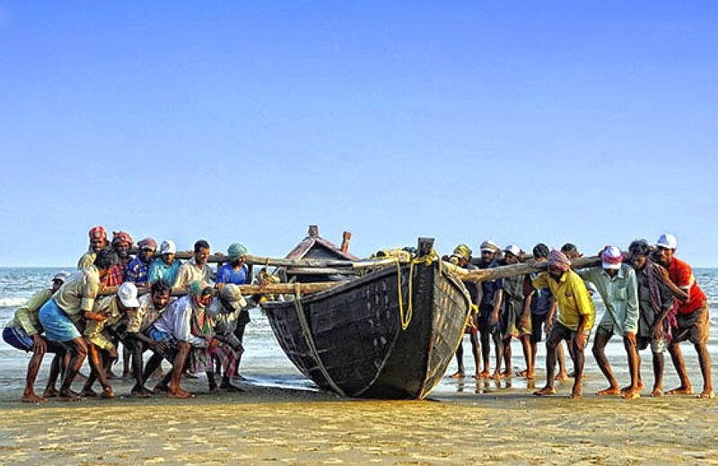 Fishermen pulling boat ashore