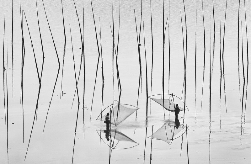 Fishermen with nets in water