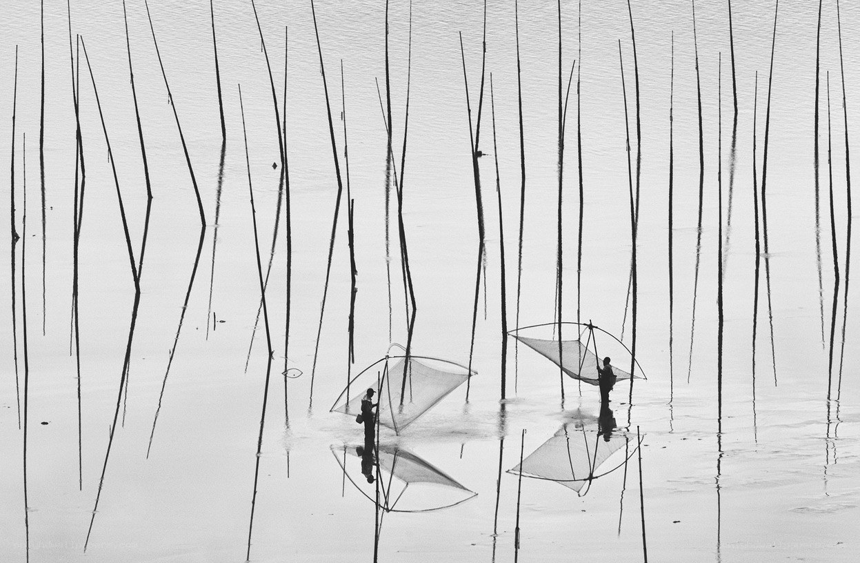 Fishermen with nets in water