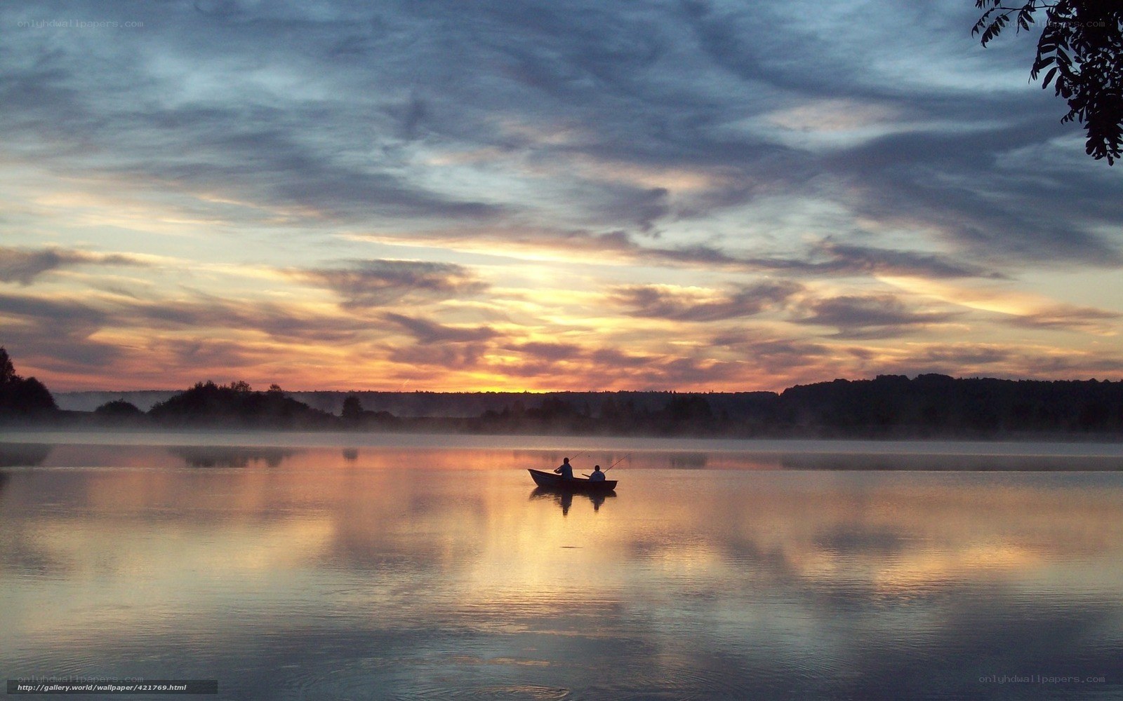 Fishing at dawn on a misty lake