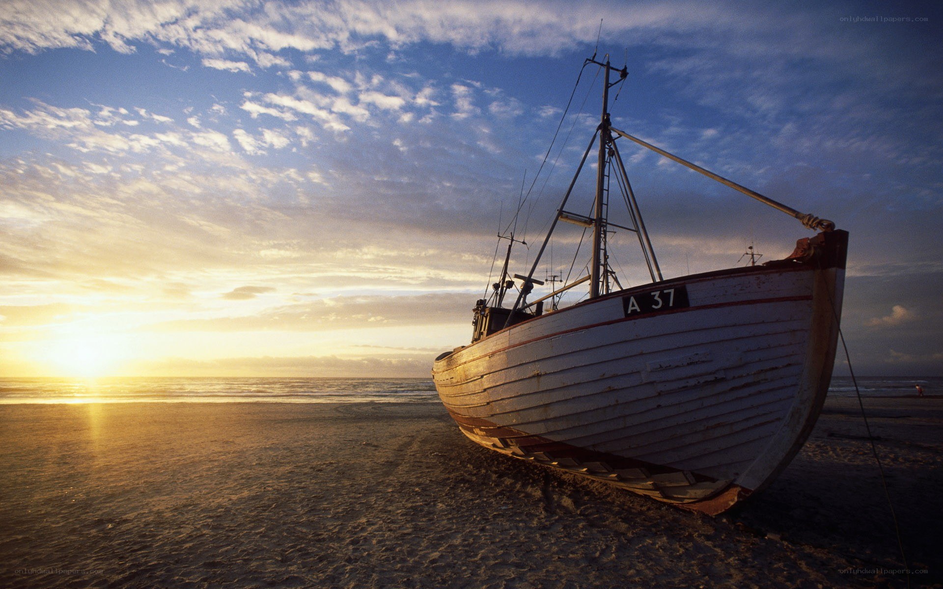 Fishing boat on beach at sunset