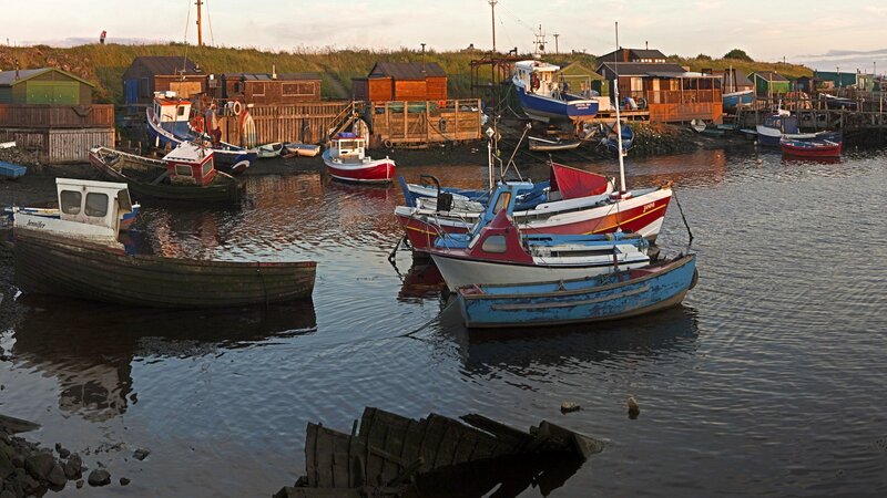 Fishing boats in a harbor at dusk