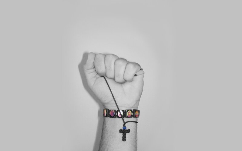fist with religious bracelet