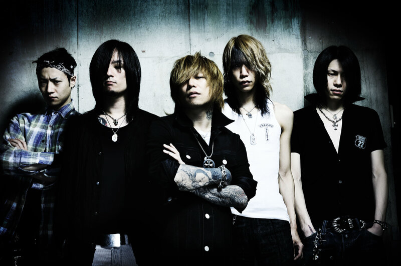 Five Band Members Standing — Black, Serious